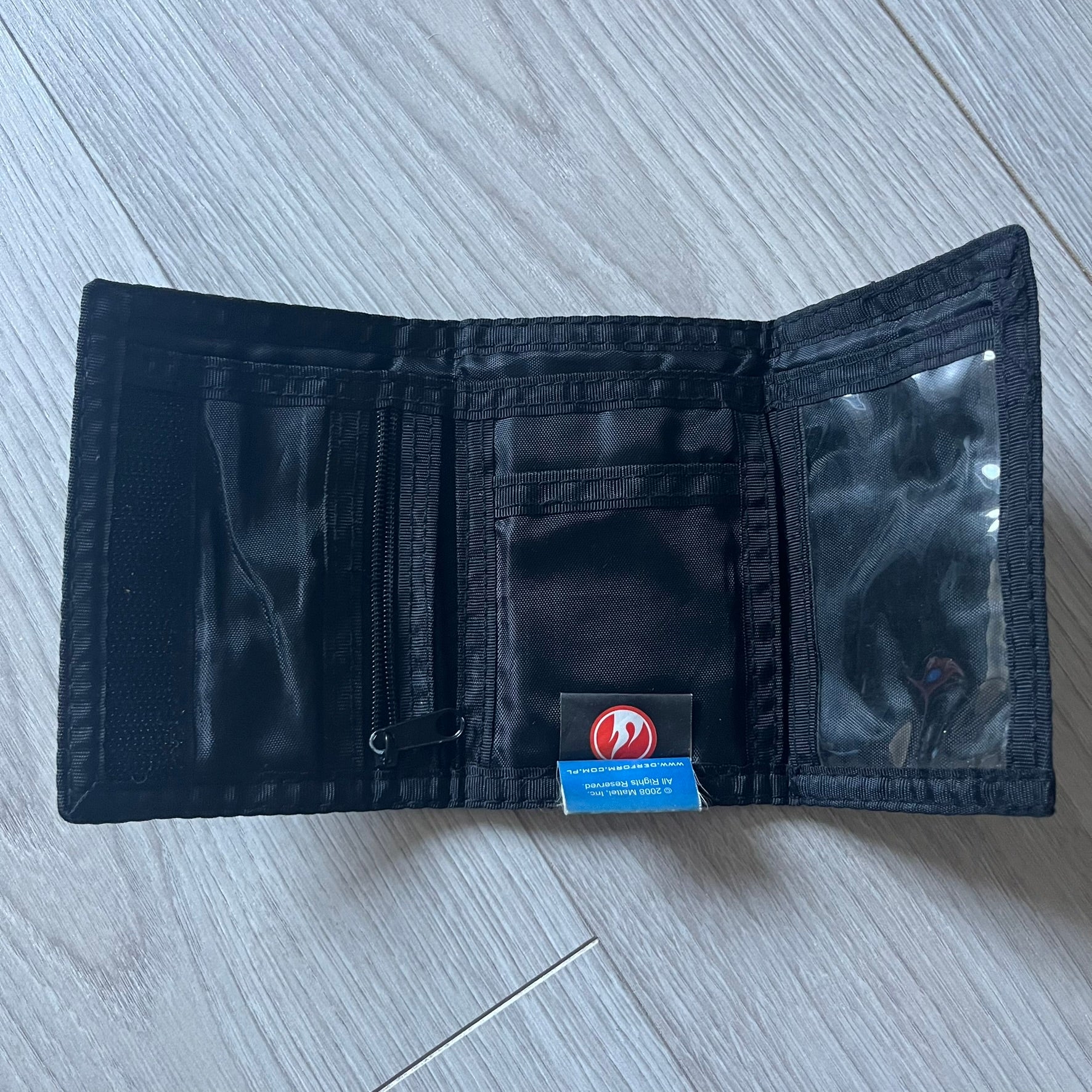2008 Hot Wheels 24/Seven wallet in black with a detailed blue 24/Seven Car graphic under a protective plastic laminate. Includes Hot Wheels logo detailing, Mattel tags, and plenty of compartments for storage. A functional piece with nostalgic collector appeal.