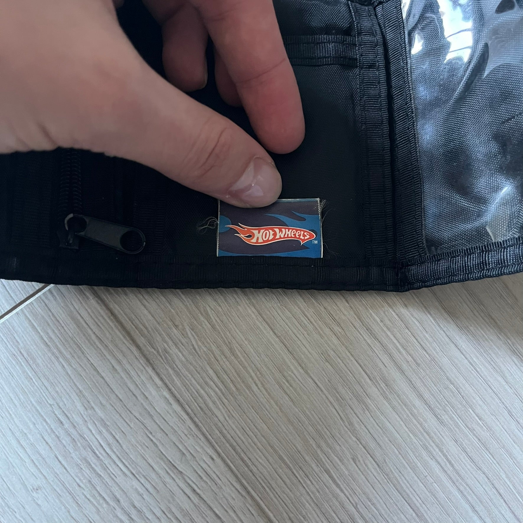 2008 Hot Wheels 24/Seven wallet in black with a detailed blue 24/Seven Car graphic under a protective plastic laminate. Includes Hot Wheels logo detailing, Mattel tags, and plenty of compartments for storage. A functional piece with nostalgic collector appeal.