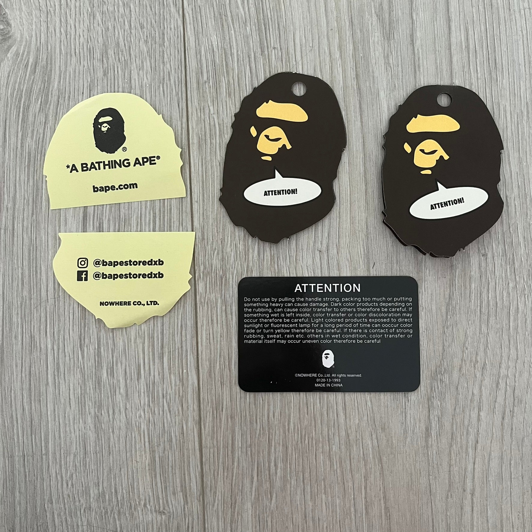 Bape branded product tags on a wooden surface
