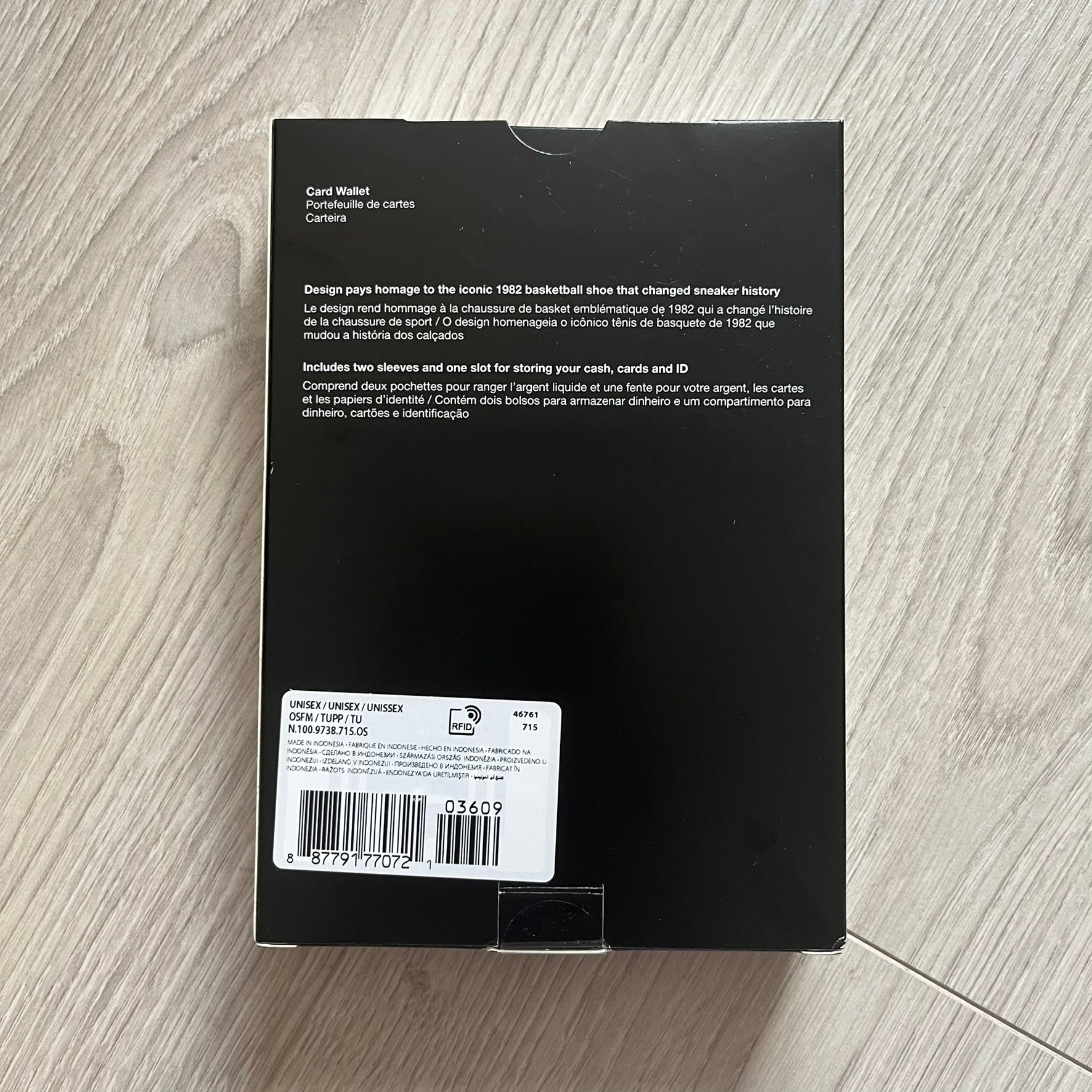 Black box with text and a barcode on a wooden surface