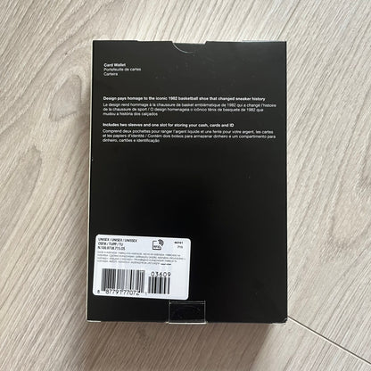 Black box with text and a barcode on a wooden surface