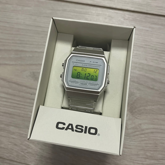 Digital watch in a Casio packaging box on a wooden surface.