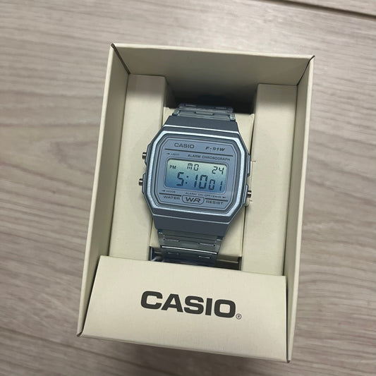 Casio digital watch in a box on a wooden surface