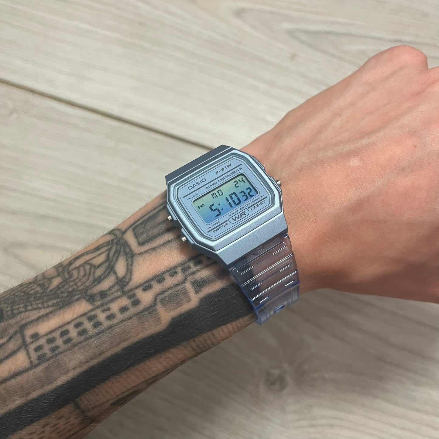 Silver digital watch on a wrist with a light background