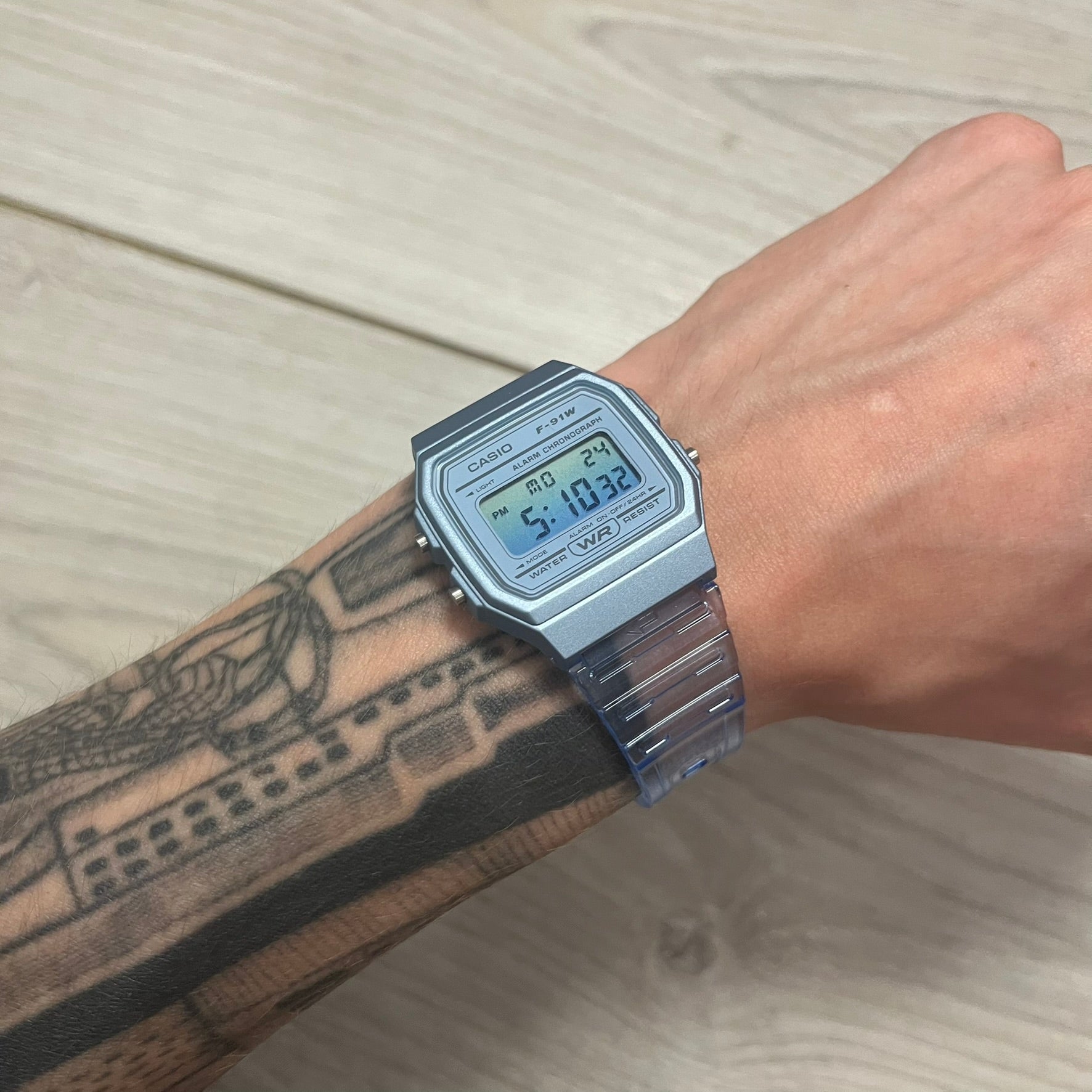 Silver digital watch on a wrist with a light background
