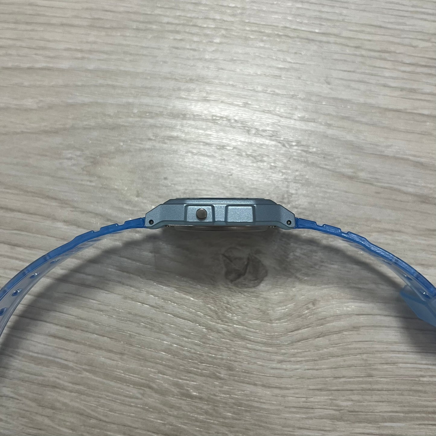 Close-up of a blue wristband on a wooden surface.