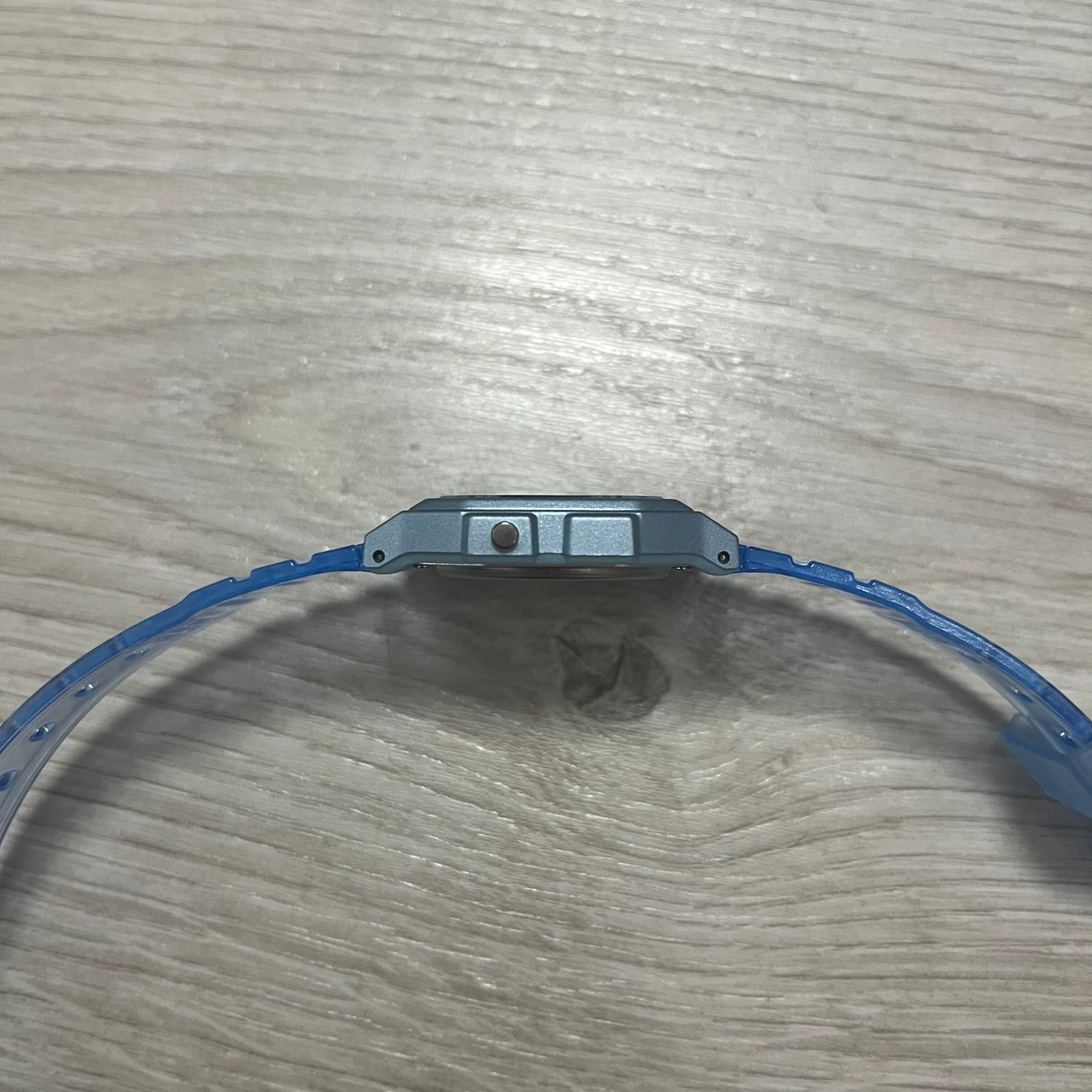 Close-up of a blue wristband on a wooden surface.