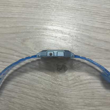 Close-up of a blue wristband on a wooden surface.