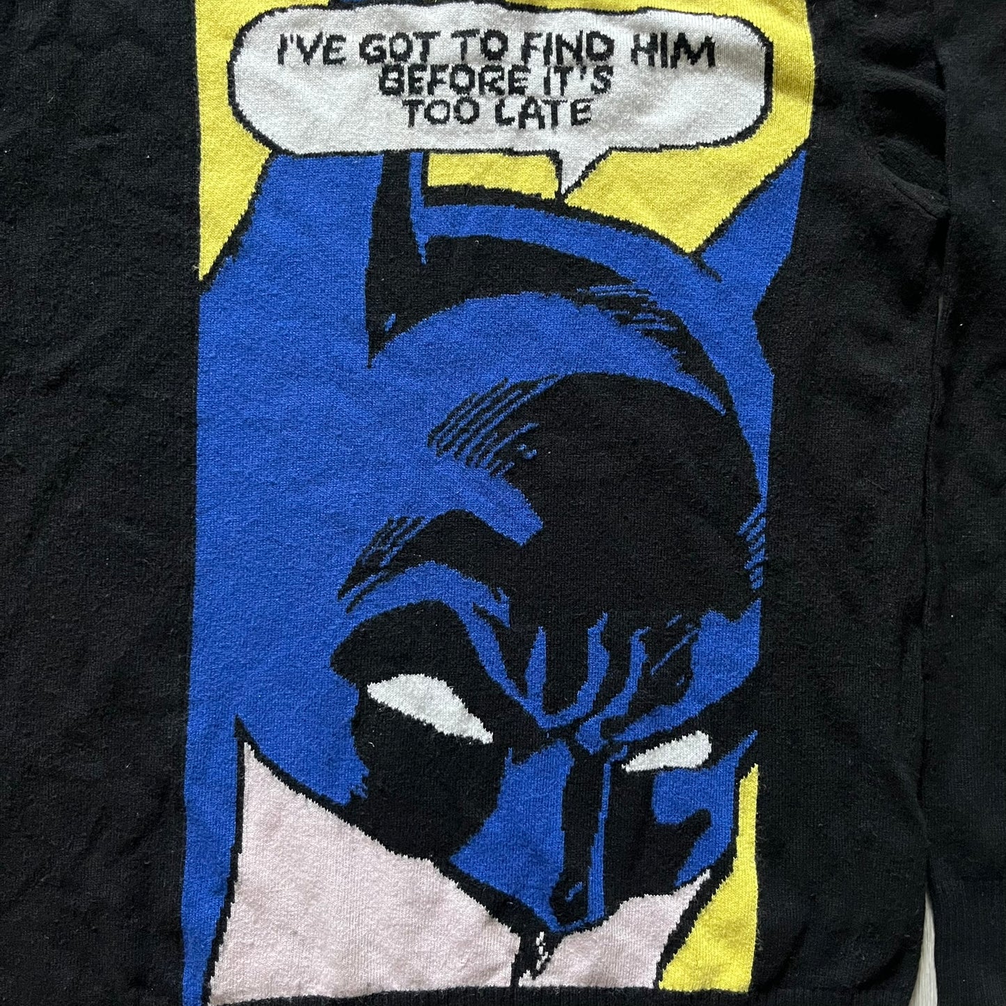 Iceberg Batman 2016 Black Sweater crafted from a premium blend of polyamide, wool, cashmere, and viscose. Features a large woven Batman comic-style graphic on a yellow background with the quote “I’ve got to find him before it’s too late.” Officially licensed by DC, released as part of the Spring/Summer 2016 collection.