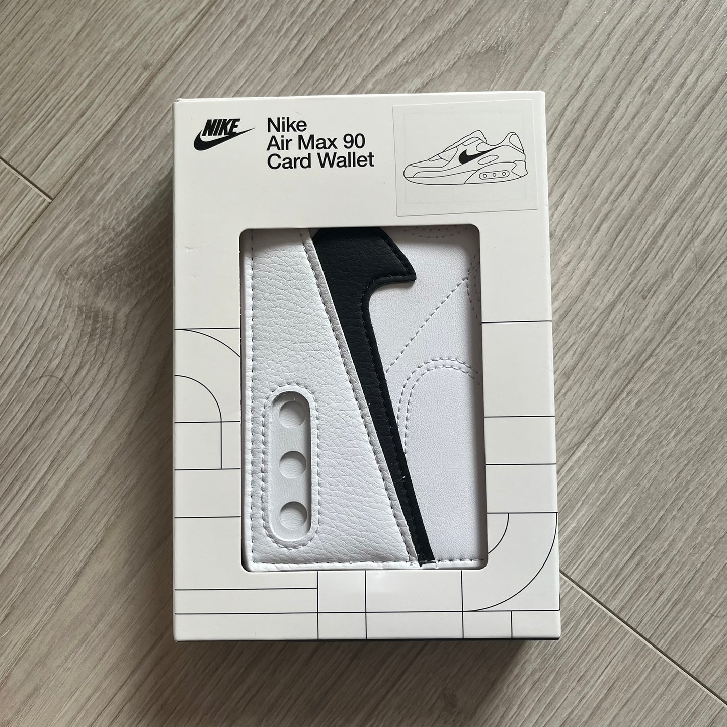 Nike Air Max 90 card wallet packaging on a wooden surface