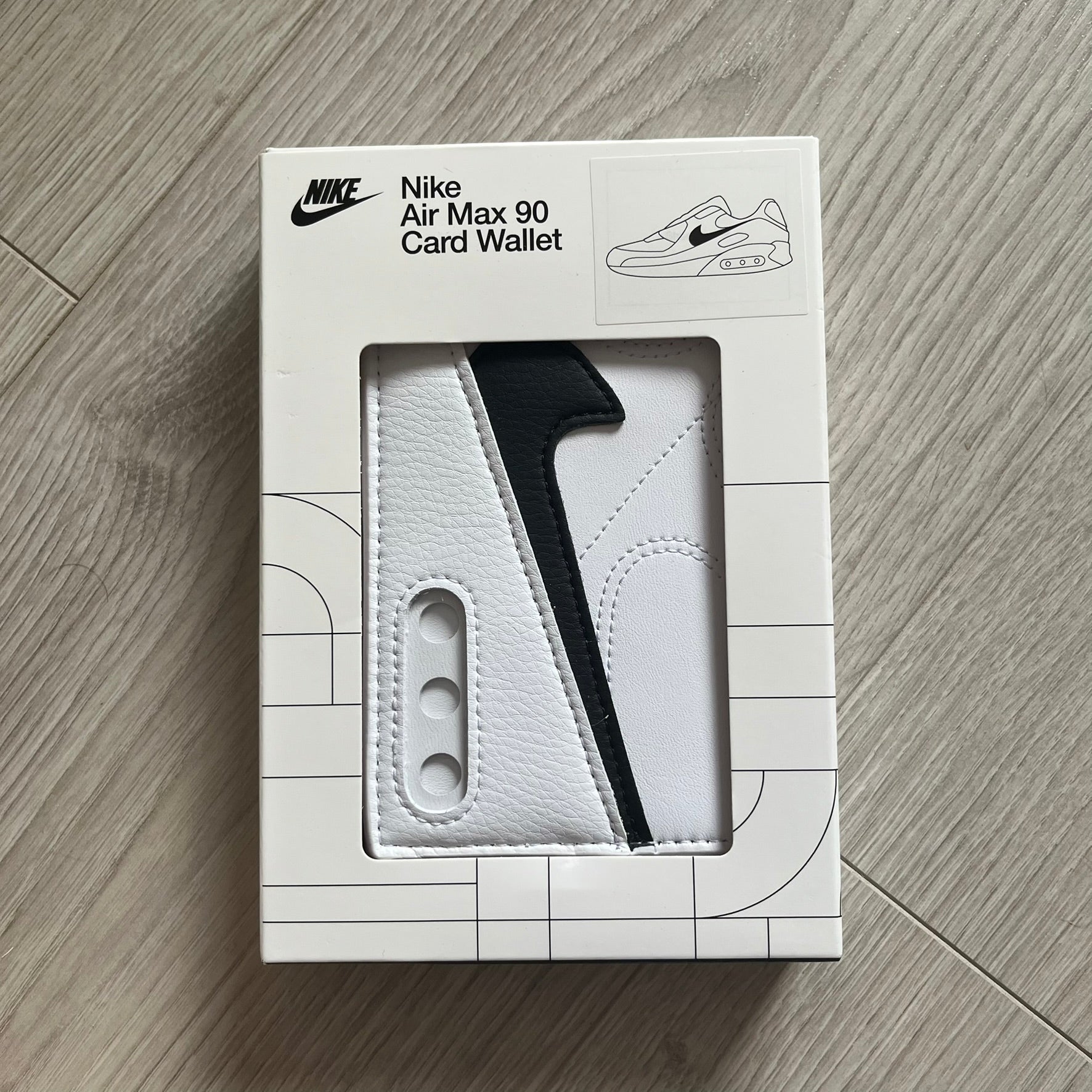 Nike Air Max 90 card wallet packaging on a wooden surface