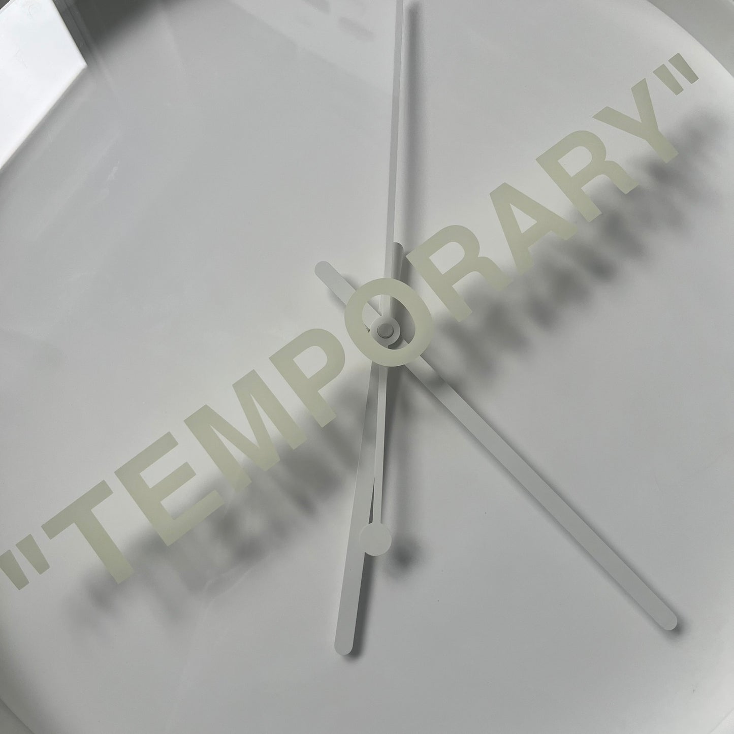 Ikea MARKERAD x Virgil Abloh “Temporary” Wall Clock is a white minimalist wall clock released on November 1, 2019 as part of the IKEA MARKERAD collaboration. It features a clean all-white design with a plexiglass cover and the word “TEMPORARY” printed across the face. The dial has no numerals, using only simple hour, minute, and second hands for time display.