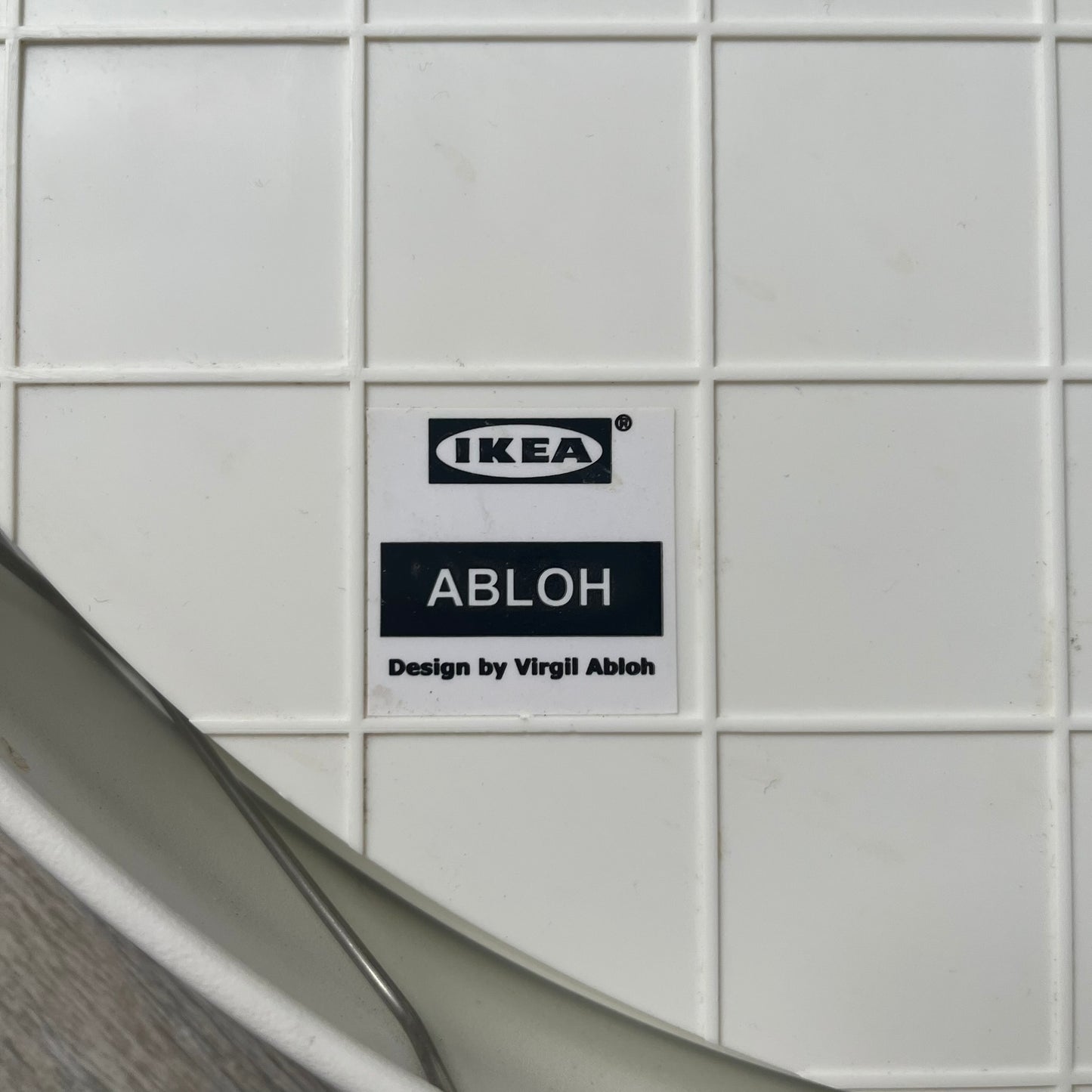 Ikea MARKERAD x Virgil Abloh “Temporary” Wall Clock is a white minimalist wall clock released on November 1, 2019 as part of the IKEA MARKERAD collaboration. It features a clean all-white design with a plexiglass cover and the word “TEMPORARY” printed across the face. The dial has no numerals, using only simple hour, minute, and second hands for time display.