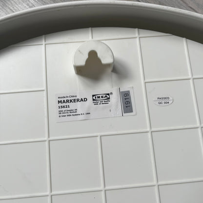 Ikea MARKERAD x Virgil Abloh “Temporary” Wall Clock is a white minimalist wall clock released on November 1, 2019 as part of the IKEA MARKERAD collaboration. It features a clean all-white design with a plexiglass cover and the word “TEMPORARY” printed across the face. The dial has no numerals, using only simple hour, minute, and second hands for time display.