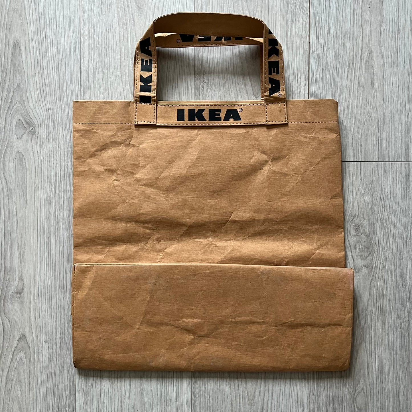 Ikea x Virgil Abloh Markerad "Sculpture" Carrier Bag from FW19 reimagines the iconic blue Frakta tote in reinforced brown paper. Embellished with Abloh’s signature quotation marks, the “SCULPTURE” print transforms a utilitarian object into conceptual design. A collectible symbol of functional art and everyday irony.
