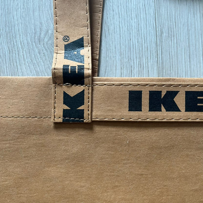 Ikea x Virgil Abloh Markerad "Sculpture" Carrier Bag from FW19 reimagines the iconic blue Frakta tote in reinforced brown paper. Embellished with Abloh’s signature quotation marks, the “SCULPTURE” print transforms a utilitarian object into conceptual design. A collectible symbol of functional art and everyday irony.