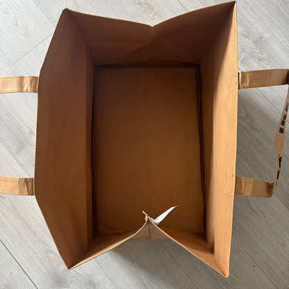 Ikea x Virgil Abloh Markerad "Sculpture" Carrier Bag from FW19 reimagines the iconic blue Frakta tote in reinforced brown paper. Embellished with Abloh’s signature quotation marks, the “SCULPTURE” print transforms a utilitarian object into conceptual design. A collectible symbol of functional art and everyday irony.