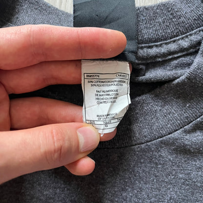 Hand holding a clothing label on gray fabric