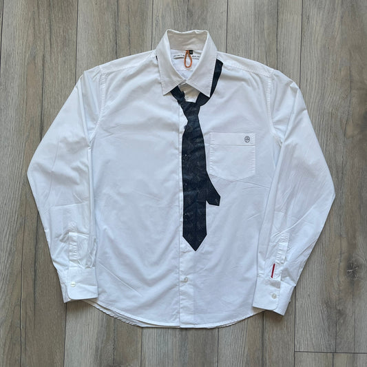 JC De Castelbajac AW08 Loose Tie Shirt is a white long-sleeve shirt from the Autumn/Winter 2008 collection, made in Italy from 100% cotton. The design features a printed navy tie with JC monogram on the front, a chest pocket with small logo embroidery, and additional logo embroidery on the back below the collar and on the sleeve. It includes mother-of-pearl buttons with contrasting white and navy detailing, matching the printed tie graphic.