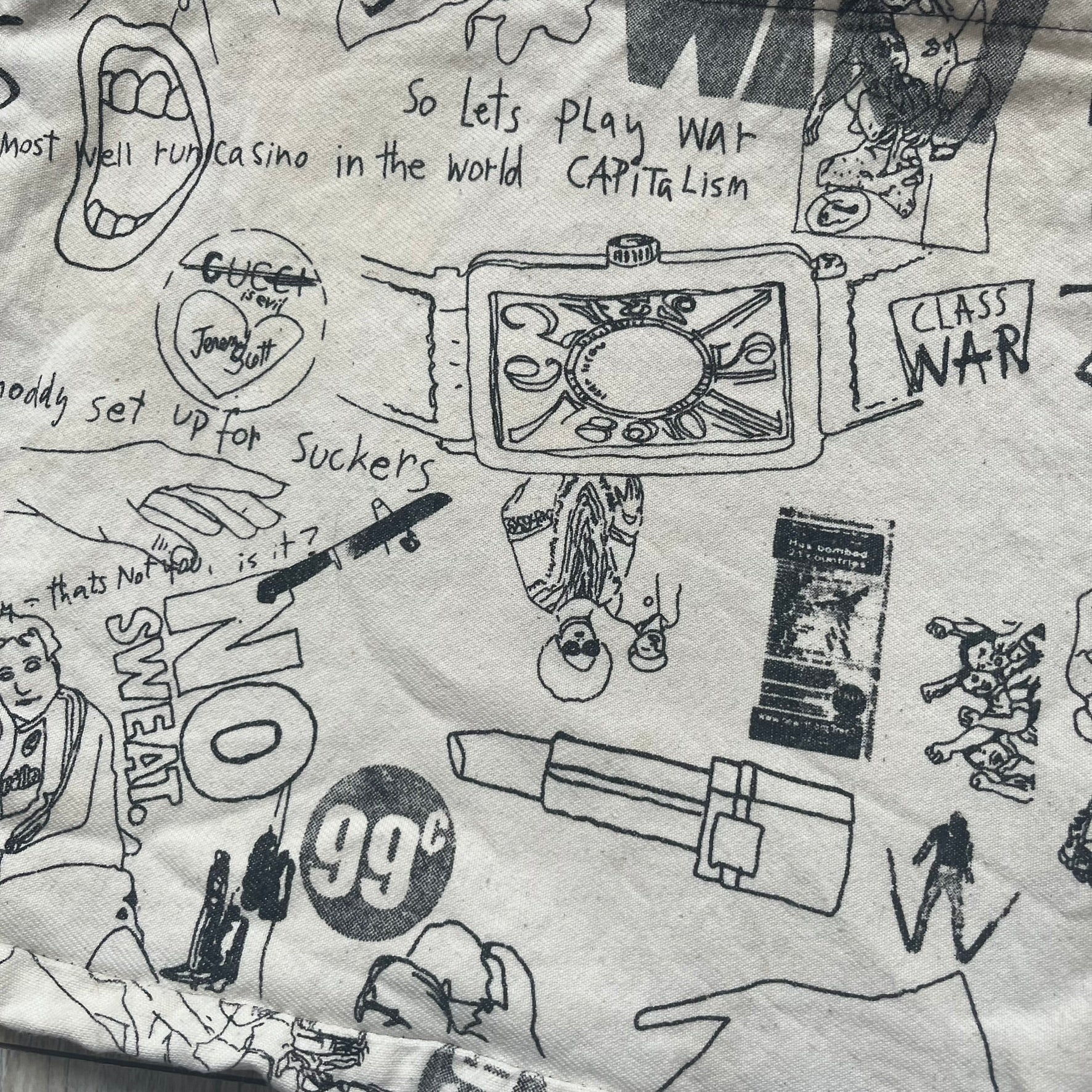 Jeremy Scott 2004 Chicks on Speed: It’s a Project Tote Bag is a cream canvas tote featuring multiple black hand-drawn style graphics including symbols, objects, and abstract motifs such as text elements, crossed-out luxury references, lips, watches, chains, and figures. The bag was originally part of a limited art publication kit released in 2004. It came with additional included items such as a book, poster, CD, clothing pattern, and fabric components as part of the full “Chicks on Speed: It’s a Project” s