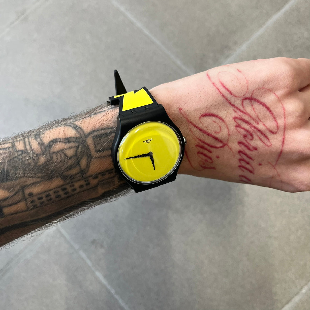 Jeremy Scott Swatch 2011 Lightning Flash Analog Watch (SUOZ104) is a limited-edition watch released in March 2011 from Jeremy Scott's first collaboration with Swatch. It features a black and yellow design with lightning bolt-shaped rubber straps, a yellow dial with a black case, lightning bolt-shaped hands, and a Jeremy Scott signature on the back.