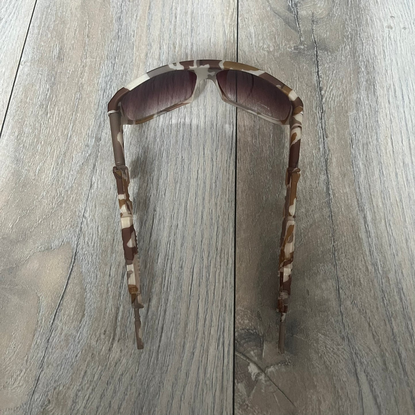 Jeremy Scott x Linda Farrow SS2013 Desert Camo M16 Rifle Sunglasses (JSARMYC4SUN) are a statement eyewear piece from the Spring/Summer 2013 collaboration. The design features full camo brown and beige frames with red/pink lenses, while the arms are constructed as detailed 3D M16 rifle shapes extending toward the front of the frame. The model includes Jeremy Scott branding on the inner arms and is produced in a high-detail acetate construction.