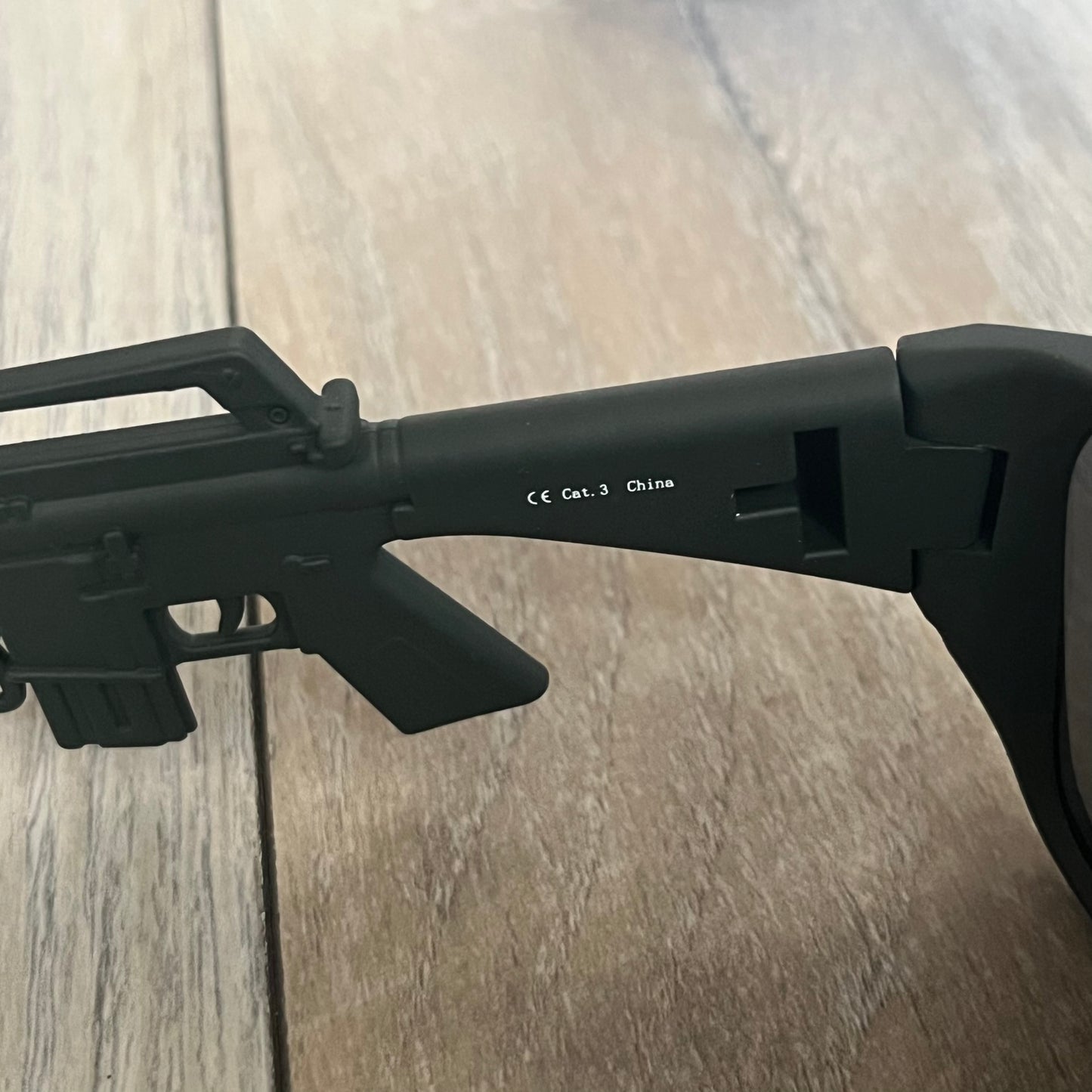 Jeremy Scott x Linda Farrow SS2013 Matt Khaki M16 Rifle Sunglasses (JSARMYC5SUN) are a statement eyewear piece from the Spring/Summer 2013 collaboration. The design features full matt dark khaki frames with black lenses, while the arms are constructed as detailed 3D M16 rifle shapes extending toward the front of the frame. The model includes Jeremy Scott branding on the inner arms and is produced in a high-detail acetate construction.