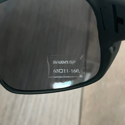 Jeremy Scott x Linda Farrow SS2013 Matt Khaki M16 Rifle Sunglasses (JSARMYC5SUN) are a statement eyewear piece from the Spring/Summer 2013 collaboration. The design features full matt dark khaki frames with black lenses, while the arms are constructed as detailed 3D M16 rifle shapes extending toward the front of the frame. The model includes Jeremy Scott branding on the inner arms and is produced in a high-detail acetate construction.