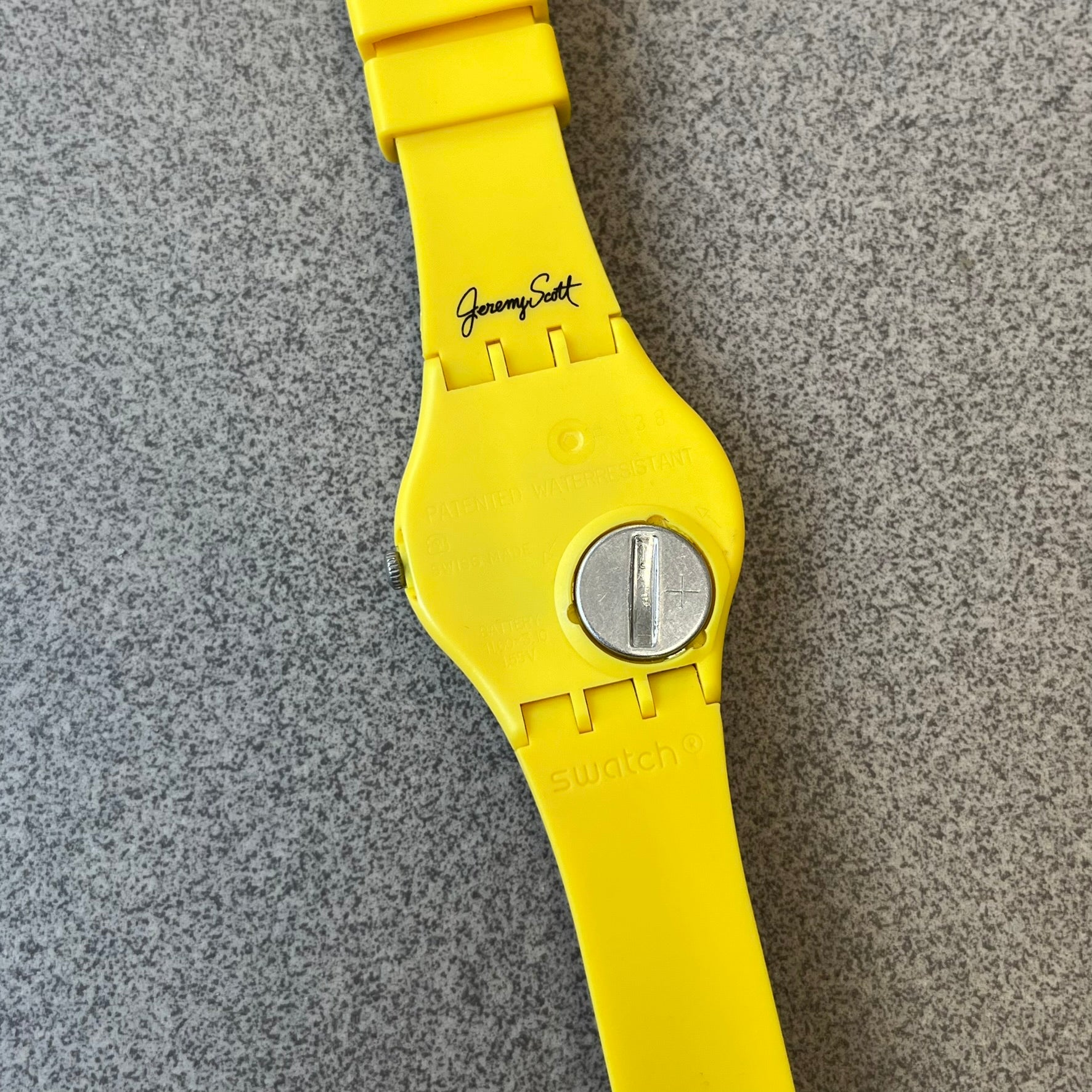Swatch x Jeremy Scott 2011 Punk Analog Watch GZ251 is a quartz watch from the Gent Original line featuring a bright green dial with black hands and a plastic case. The design includes a comically long silicone strap with leopard print that wraps twice around the wrist, secured with multiple yellow loops, and Jeremy Scott branding on the upper strap.