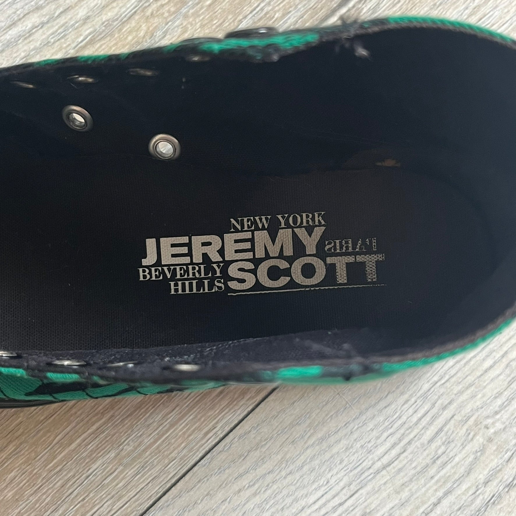 Jeremy Scott x adidas 2014 Nizza Hi “Forest Green” Sneakers are made with a forest green canvas upper featuring an all-over black tiger print. The high-top shoes include rubber soles and standard adidas Nizza tooling. This model was released in 2014 in a green and black colorway as part of the Jeremy Scott x adidas collaboration.