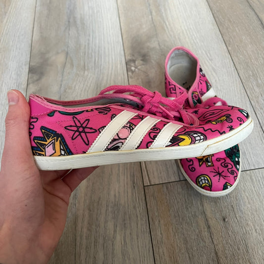 Jeremy Scott x adidas 2014 P-Sole “Pink” Sneakers feature a pink canvas upper with white leather adidas stripes and multicolored graphic prints. Released in 2014, they are part of the P-Sole line in the collaboration between adidas Originals, Jeremy Scott, and Kenny Scharf. The shoes include standard rubber soles and lace-up closure.