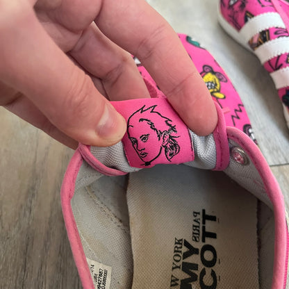 Jeremy Scott x adidas 2014 P-Sole “Pink” Sneakers feature a pink canvas upper with white leather adidas stripes and multicolored graphic prints. Released in 2014, they are part of the P-Sole line in the collaboration between adidas Originals, Jeremy Scott, and Kenny Scharf. The shoes include standard rubber soles and lace-up closure.