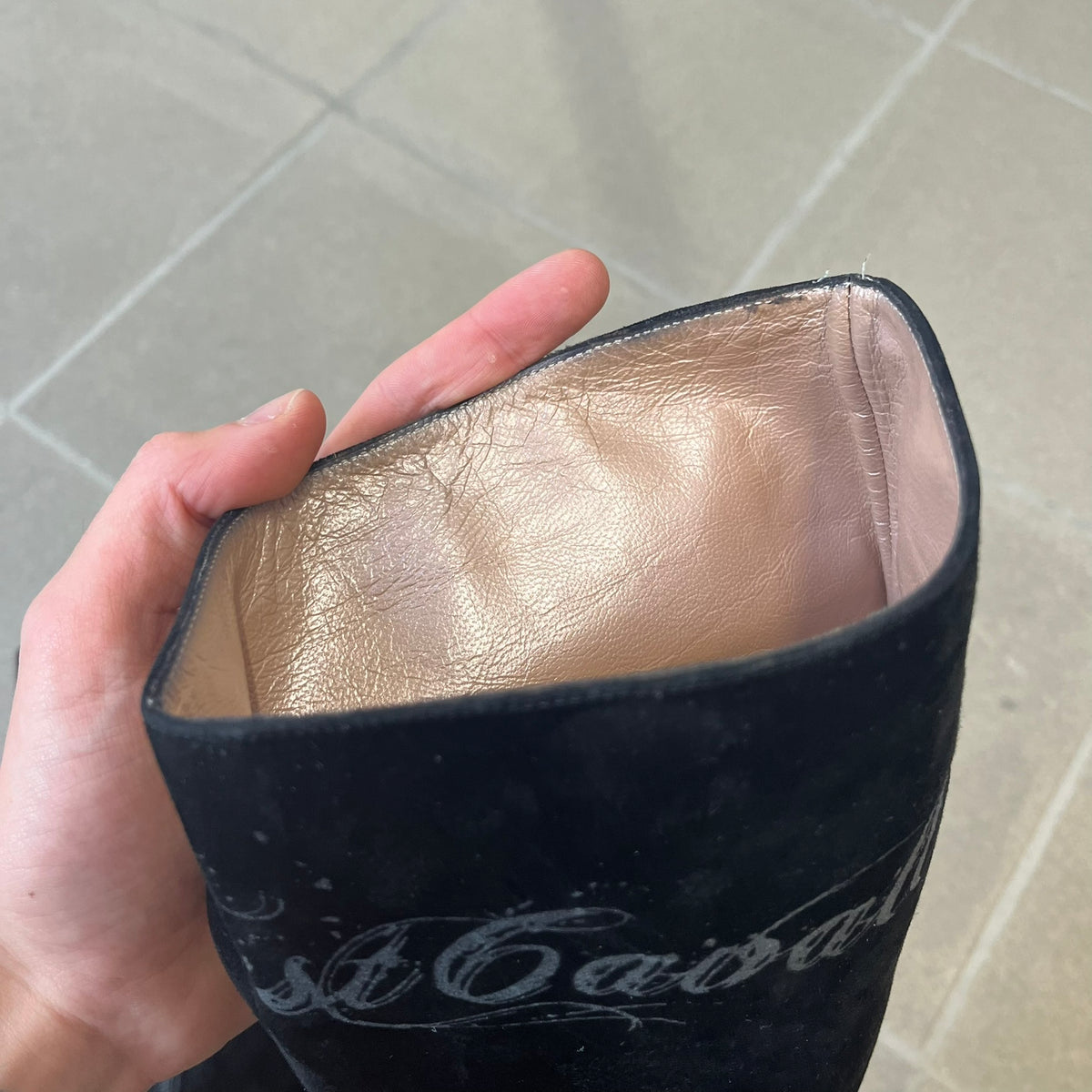 Just Cavalli 2000's Black Suede Boots are made in Italy, featuring black suede uppers with a beige sole and "Just Cavalli" branding on the bottom. A glittery silver "Just Cavalli" text logo appears at the top of the boot, with a side zipper running from the midpoint down, finished with a gold Just Cavalli horn zipper pull.