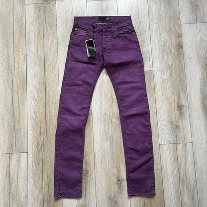 Just Cavalli 2010s Purple Slim Jeans are slim-fit denim jeans finished in a full purple colorway. The pair features classic front and back pocket construction, branded metal button closure, and small metal stud details on the pockets. Additional details include a rear leather Just Cavalli logo patch, interior Just Cavalli tag, and original paper tag.