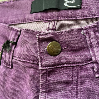 Just Cavalli 2010s Purple Slim Jeans are slim-fit denim jeans finished in a full purple colorway. The pair features classic front and back pocket construction, branded metal button closure, and small metal stud details on the pockets. Additional details include a rear leather Just Cavalli logo patch, interior Just Cavalli tag, and original paper tag.