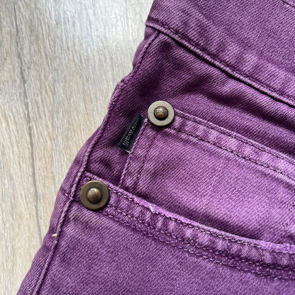 Just Cavalli 2010s Purple Slim Jeans are slim-fit denim jeans finished in a full purple colorway. The pair features classic front and back pocket construction, branded metal button closure, and small metal stud details on the pockets. Additional details include a rear leather Just Cavalli logo patch, interior Just Cavalli tag, and original paper tag.