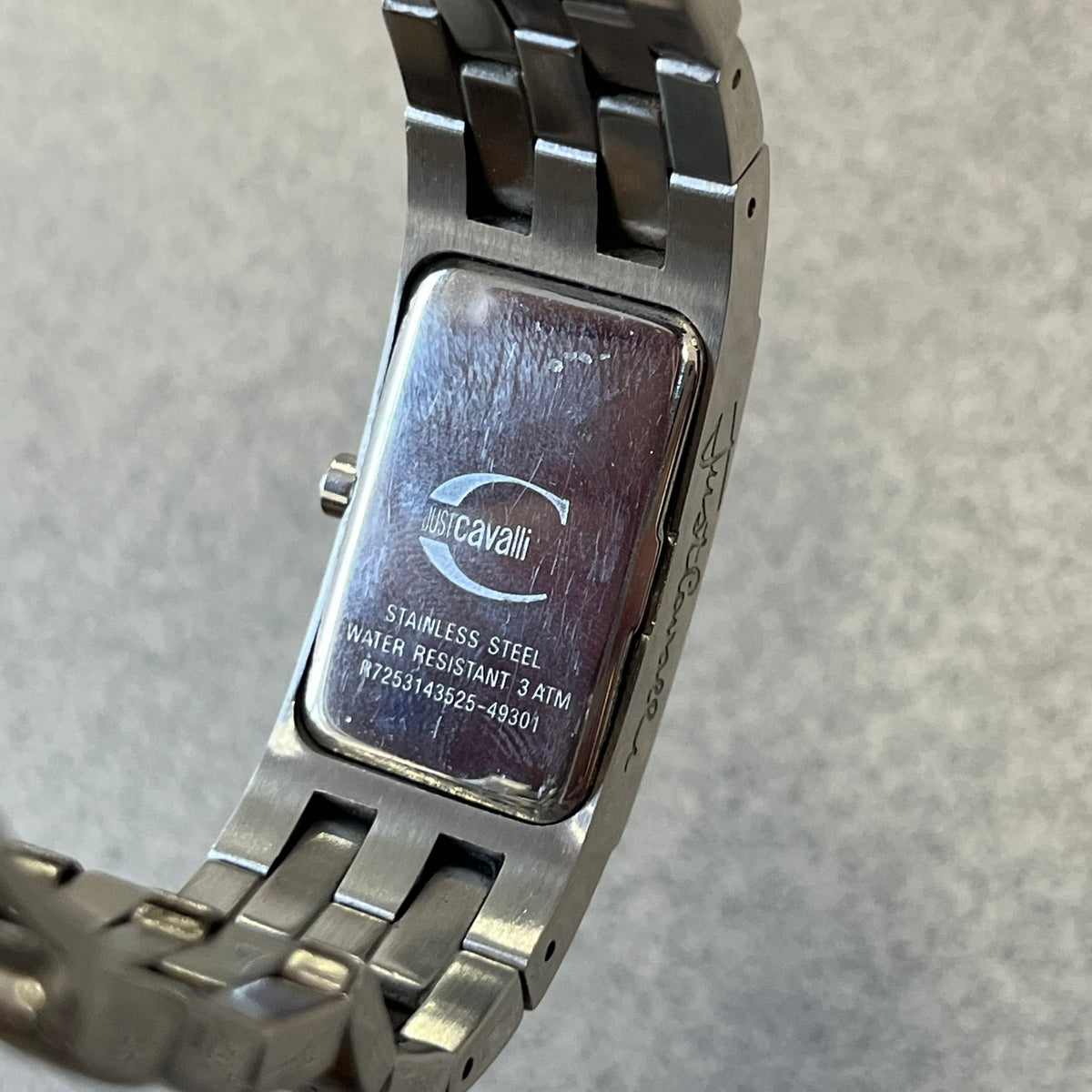 Just Cavalli Colas 2010’s Zebra Analog Watch is a stainless steel analog watch with a white and black zebra print dial and a silver Just Cavalli logo. The band matches the width of the case and has crystal details, and “Cavalli” is engraved on one side of the case.