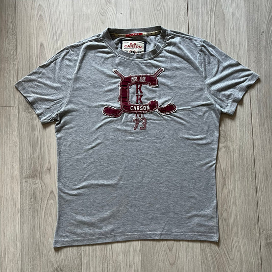Gray t-shirt with a red logo on a wooden floor