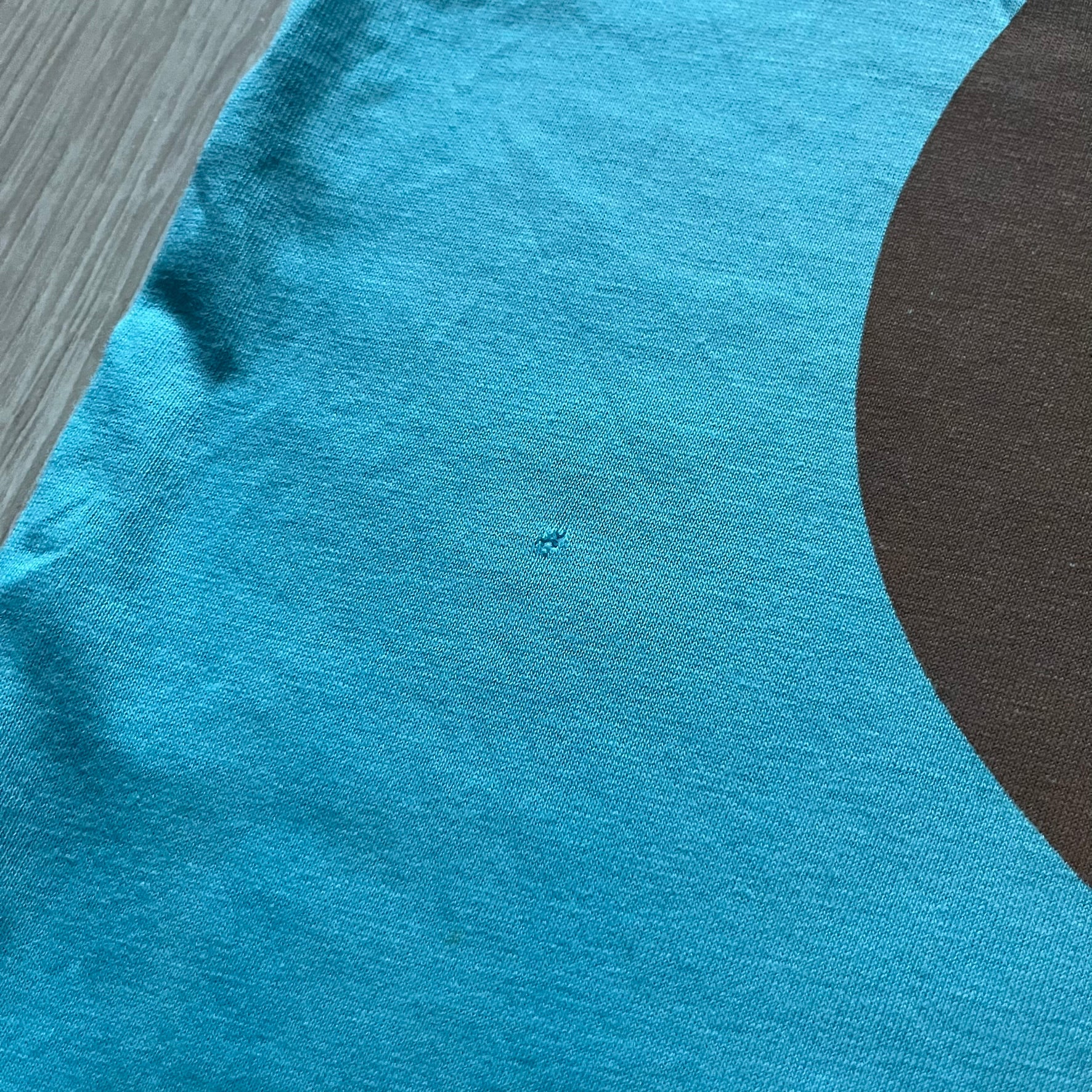 Kanye West 2012 Takashi Murakami 'Glow In The Dark Tour' Tee in light blue features the iconic bear with shutter glasses on the front. Below the graphic is yellow "kanYeWest" text and the 2007 Takashi Murakami/Kanye West licensing. Official merchandise from the 2012, this collectible tee includes the neck tag with Kanye logo and Mascotte Holdings licensing.