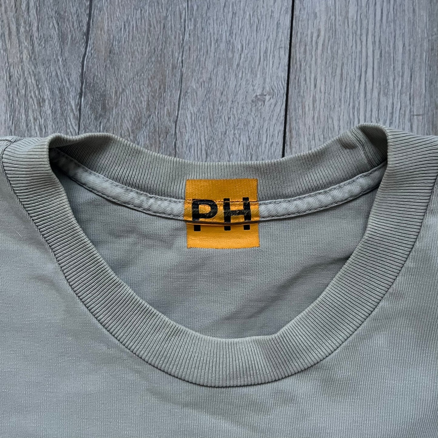 Longsleeve tee from the FW18 Kanye West x Pornhub collection, released 09/07/2018. Vapor color, featuring a front illustration of Riley Reid with her name above and “Top Female Performer” below. Back has the numbers “6918” (futuristic theme set in the year 6918). Includes printed Pornhub tag and YEEZY wash tag, part of a limited run commemorating the 2018 Pornhub Awards.