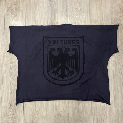 Kanye West Vultures Box Tee in navy features a large Vultures Eagles logo on the back and a smaller matching logo on the chest. Designed with an oversized, boxy silhouette, this T-shirt offers a relaxed fit. Made from high-quality, durable materials, it provides comfort for everyday wear while showcasing Yeezy’s distinctive style.