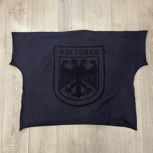 Kanye West Vultures Box Tee in navy features a large Vultures Eagles logo on the back and a smaller matching logo on the chest. Designed with an oversized, boxy silhouette, this T-shirt offers a relaxed fit. Made from high-quality, durable materials, it provides comfort for everyday wear while showcasing Yeezy’s distinctive style.