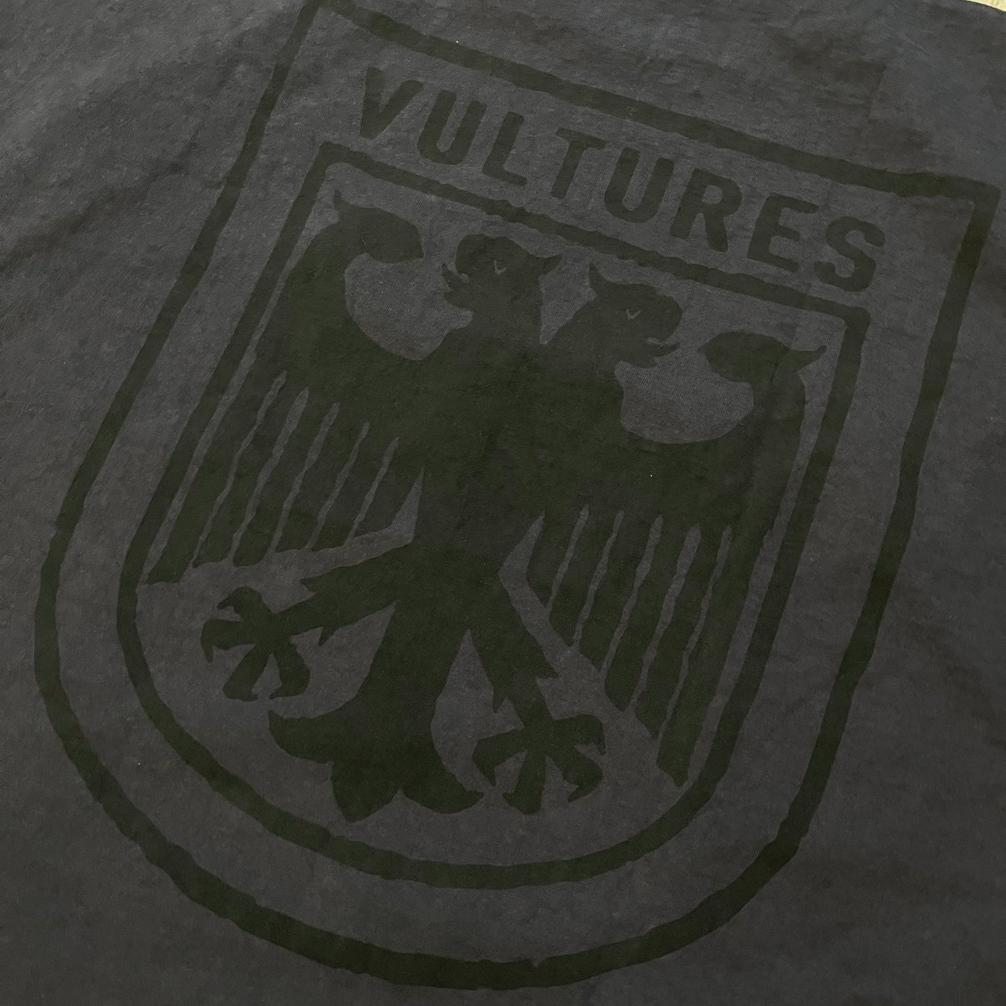 Kanye West Vultures Box Tee in navy features a large Vultures Eagles logo on the back and a smaller matching logo on the chest. Designed with an oversized, boxy silhouette, this T-shirt offers a relaxed fit. Made from high-quality, durable materials, it provides comfort for everyday wear while showcasing Yeezy’s distinctive style.