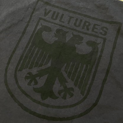 Kanye West Vultures Box Tee in navy features a large Vultures Eagles logo on the back and a smaller matching logo on the chest. Designed with an oversized, boxy silhouette, this T-shirt offers a relaxed fit. Made from high-quality, durable materials, it provides comfort for everyday wear while showcasing Yeezy’s distinctive style.