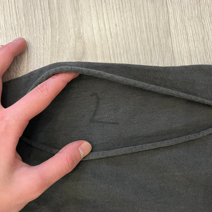 Kanye West Vultures Box Tee in washed black features a large Vultures Eagles logo on the back and a smaller matching logo on the chest. Designed with an oversized, boxy silhouette, this T-shirt offers a relaxed fit. Made from high-quality, durable materials, it provides comfort for everyday wear while showcasing Yeezy’s distinctive style.