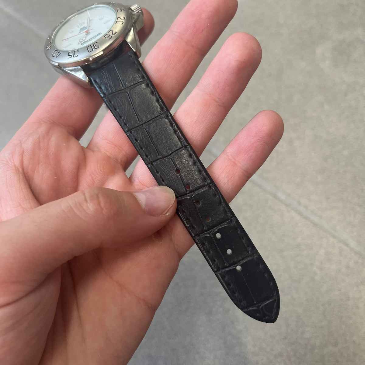 Kappa 2000's Quartz Analog Watch features black leather straps, a silver-tone case, and a white dial. The bezel is marked in five-minute increments from 5 to 55. The dial has a Kappa logo at the top and Kappa text below the center. The hour markers are represented by white dots and numerals. The watch has a stainless steel case back and is marked as a limited edition model.