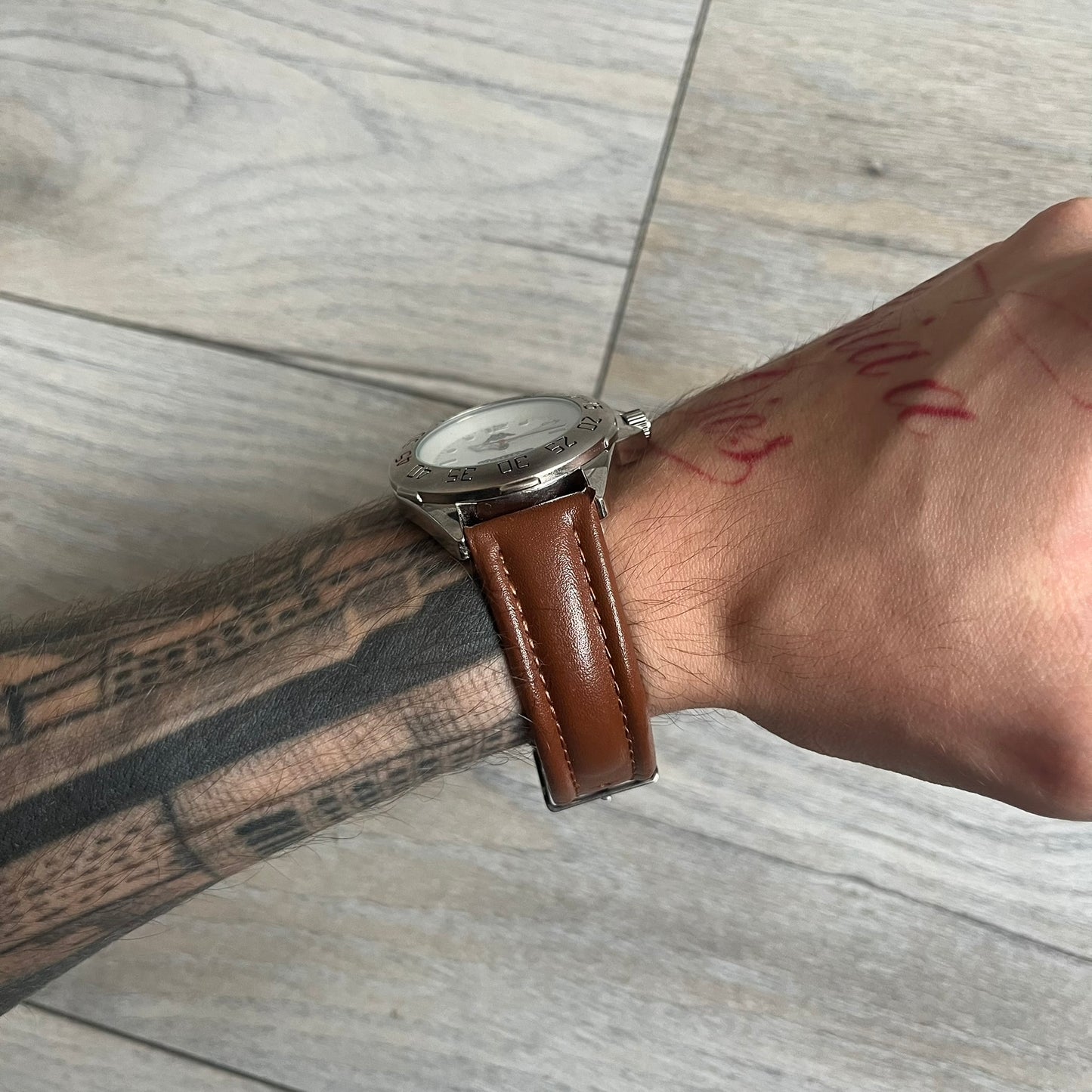 Kappa 2000s Quartz Analog Watch features brown leather straps, a silver-tone case, and a white dial. The bezel is marked in five-minute increments from 5 to 55. The dial has a Kappa logo at the top and Kappa text below the center. The hour markers are represented by white dots and numerals. The watch has a stainless steel case back and is marked as a limited edition model.