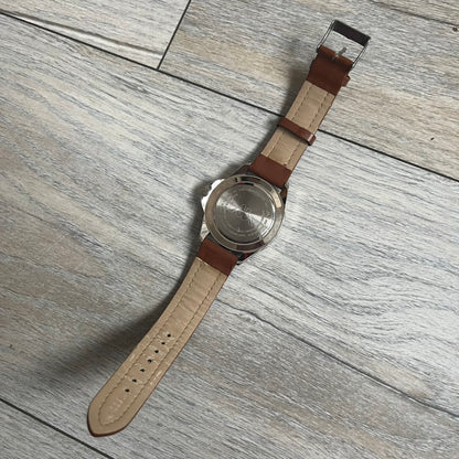 Kappa 2000s Quartz Analog Watch features brown leather straps, a silver-tone case, and a white dial. The bezel is marked in five-minute increments from 5 to 55. The dial has a Kappa logo at the top and Kappa text below the center. The hour markers are represented by white dots and numerals. The watch has a stainless steel case back and is marked as a limited edition model.