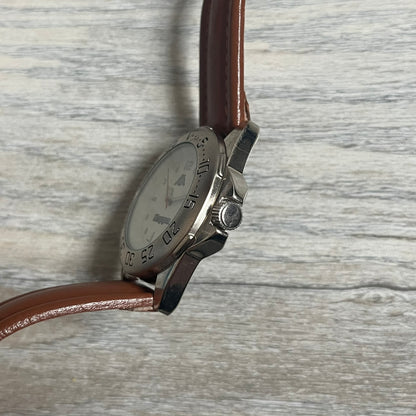 Kappa 2000s Quartz Analog Watch features brown leather straps, a silver-tone case, and a white dial. The bezel is marked in five-minute increments from 5 to 55. The dial has a Kappa logo at the top and Kappa text below the center. The hour markers are represented by white dots and numerals. The watch has a stainless steel case back and is marked as a limited edition model.