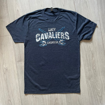 Navy blue t-shirt with 'Katy Cavaliers Lacrosse' text on a wooden floor